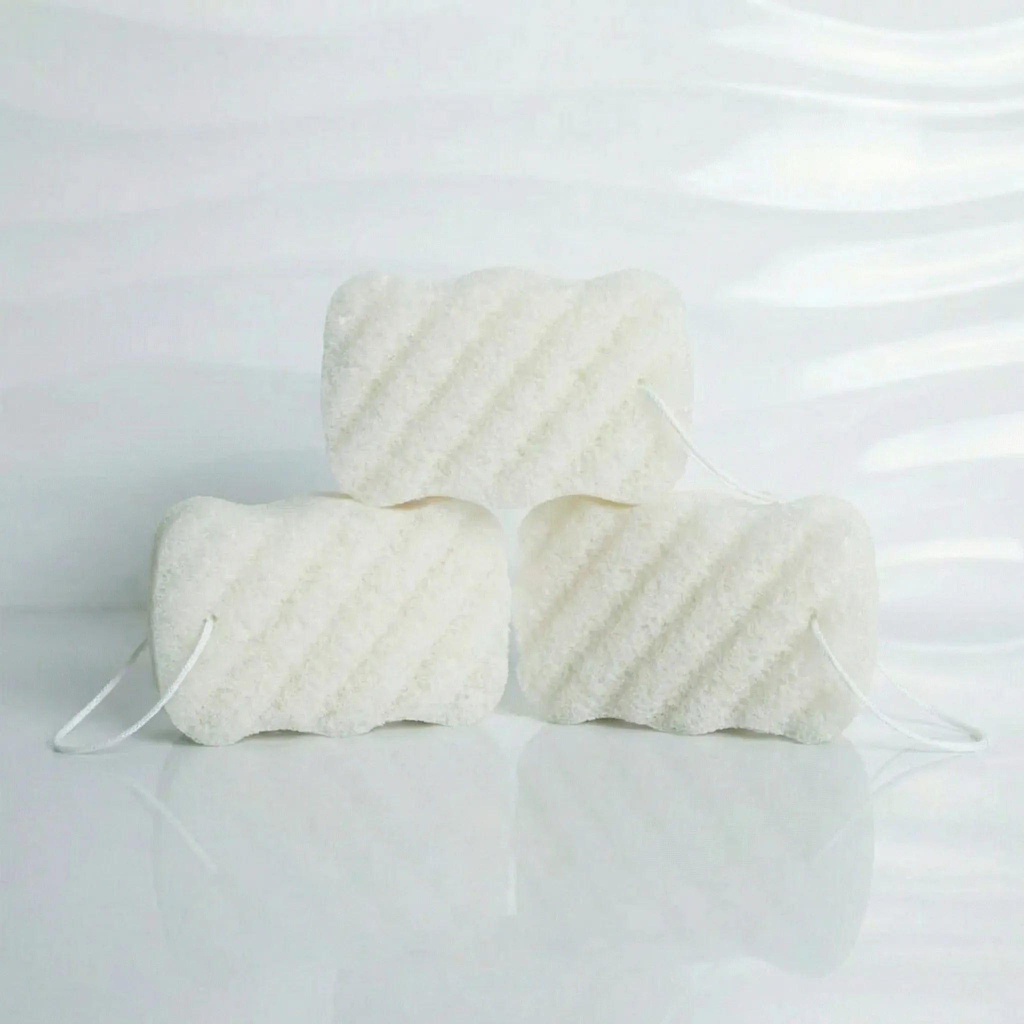 three unscented konjac body sponges with textured patterns on a light gray background