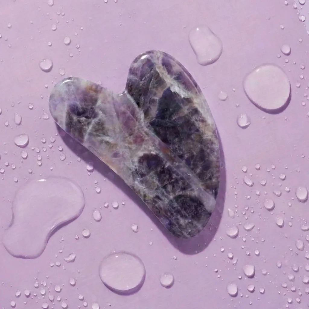 Amethyst Gua Sha displayed on purple background