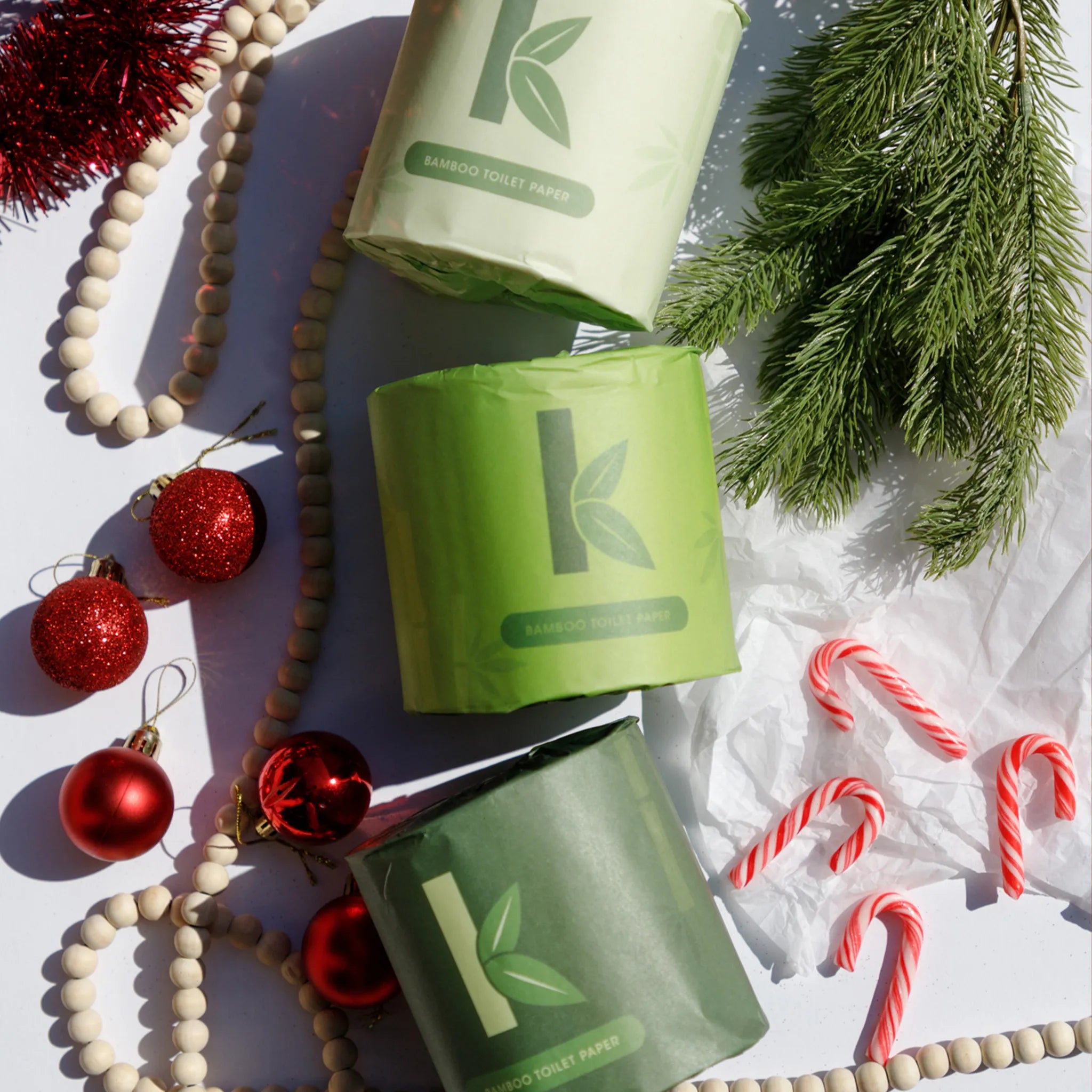 bamboo toilet paper rolls with Christmas decorations on a light surface
