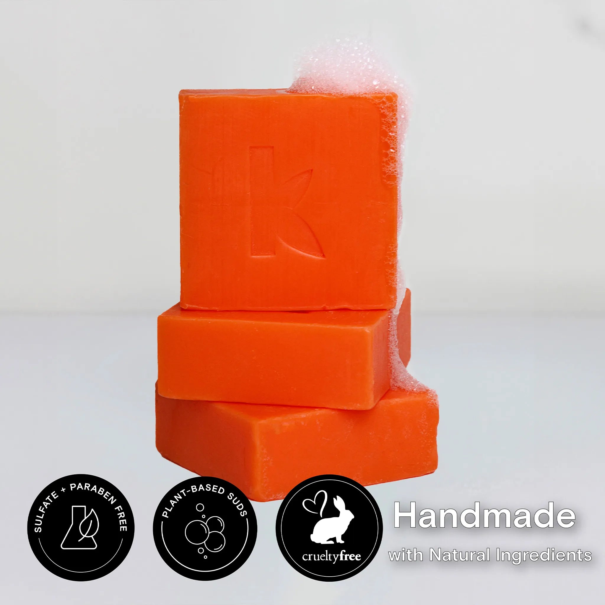 Stack of kojic acid soap bars with a brand logo on a light gray background.