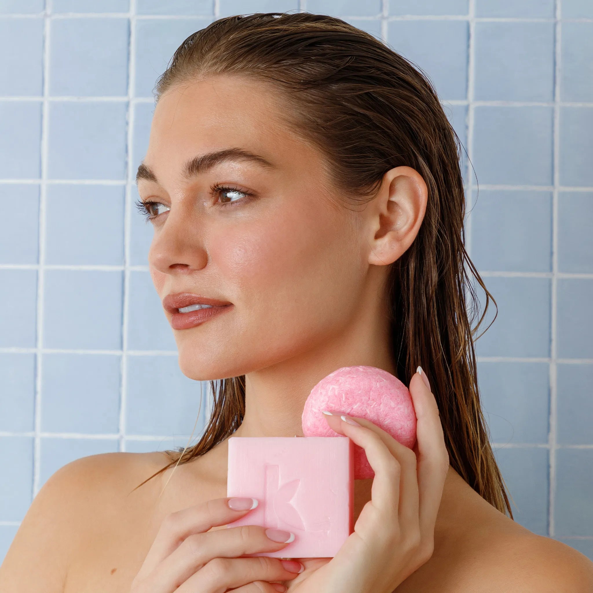 rose shampoo and soap being held by a woman