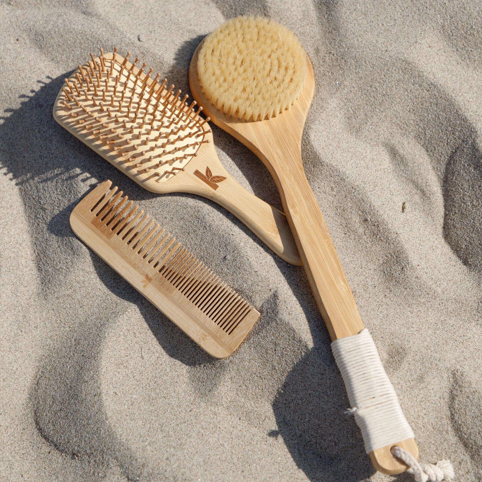 Three bamboo brushes on sand