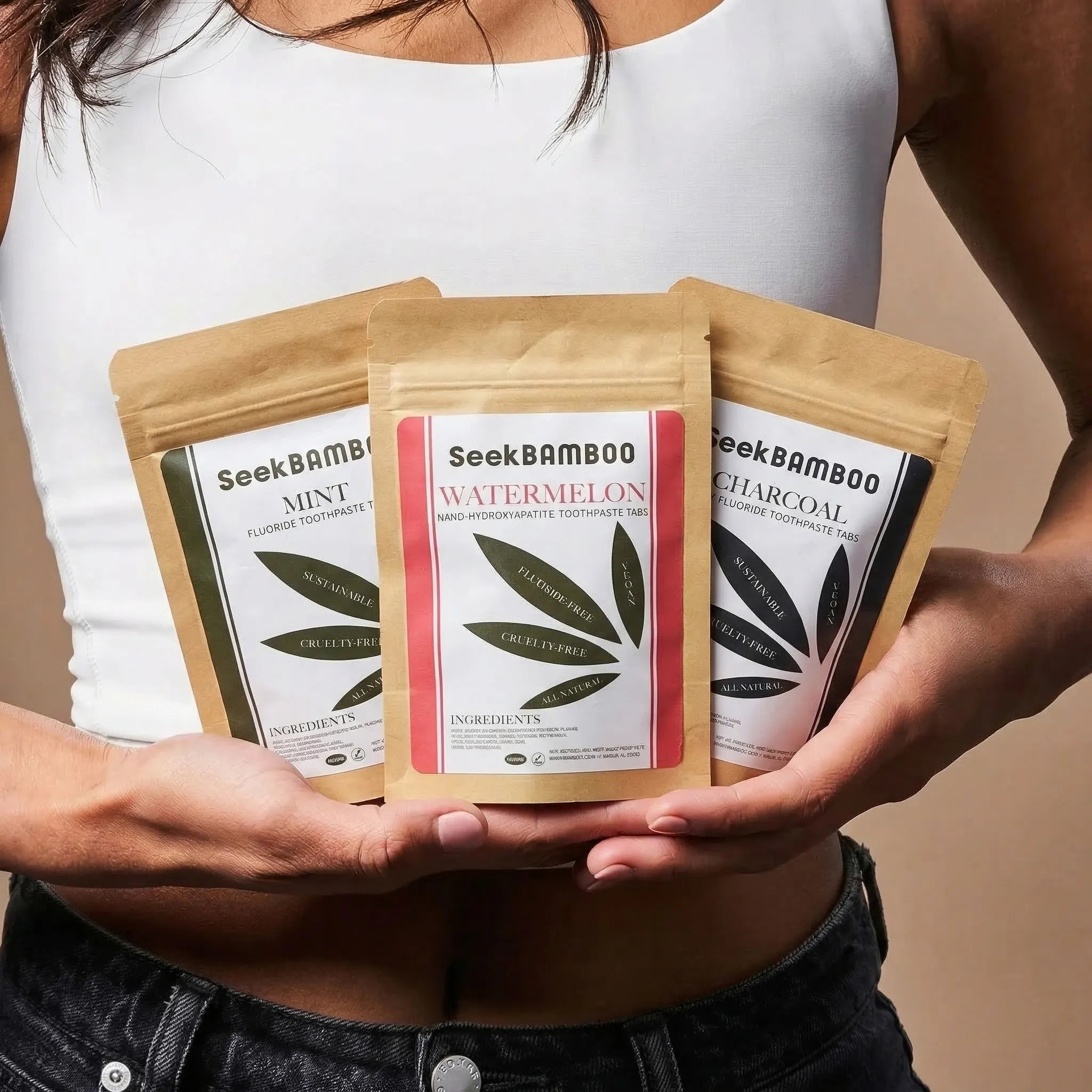 Person holding three packages of Seek Bamboo toothpaste.