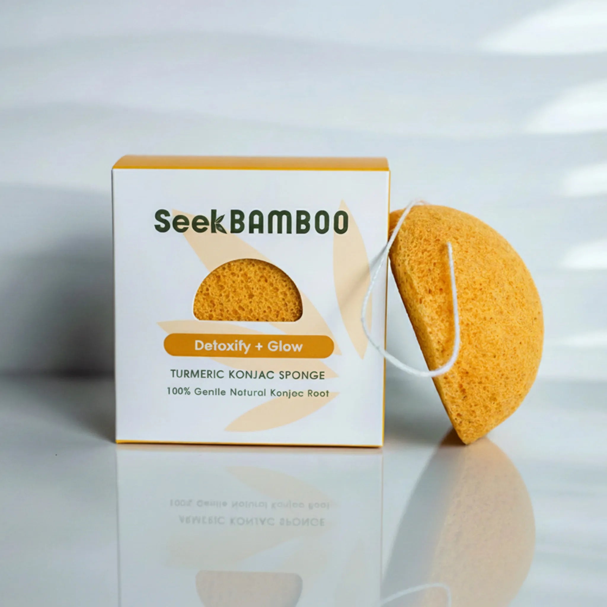 Turmeric Konjac sponge with Seek Bamboo packaging on a reflective surface