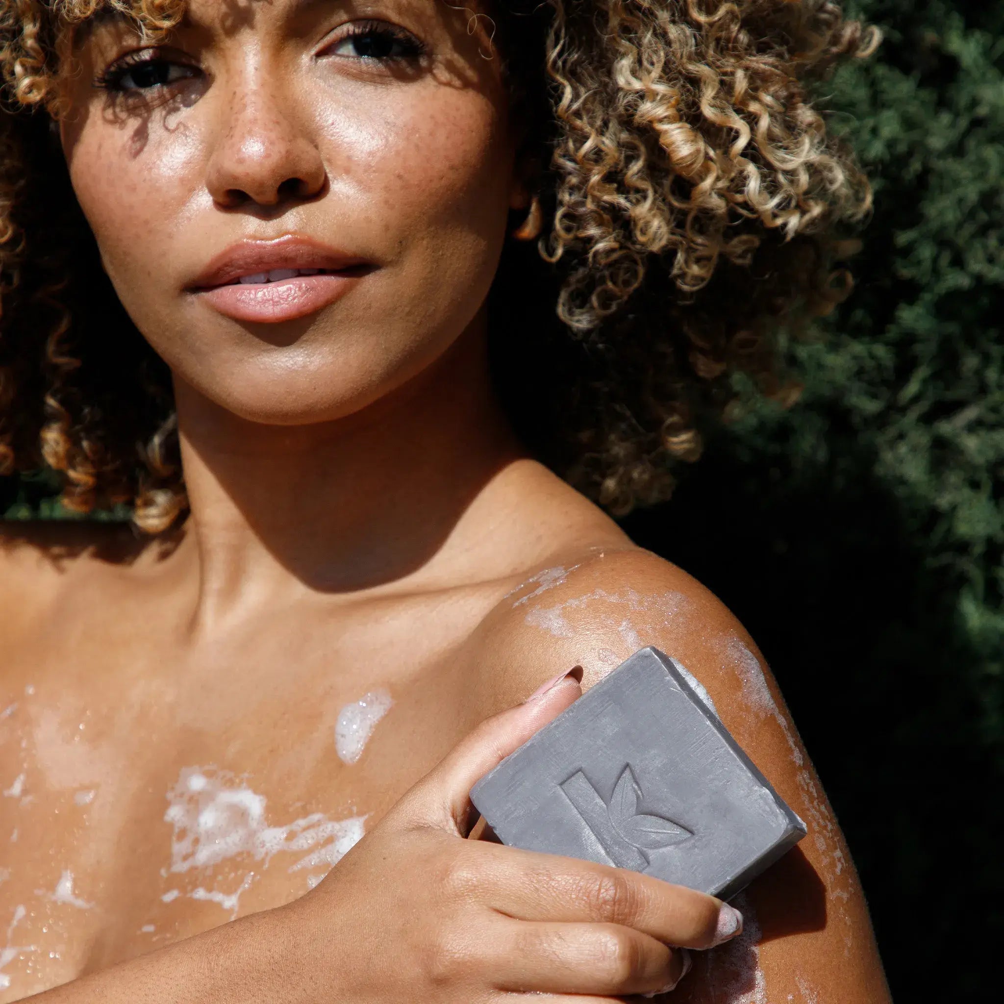 woman applying charcoal soap