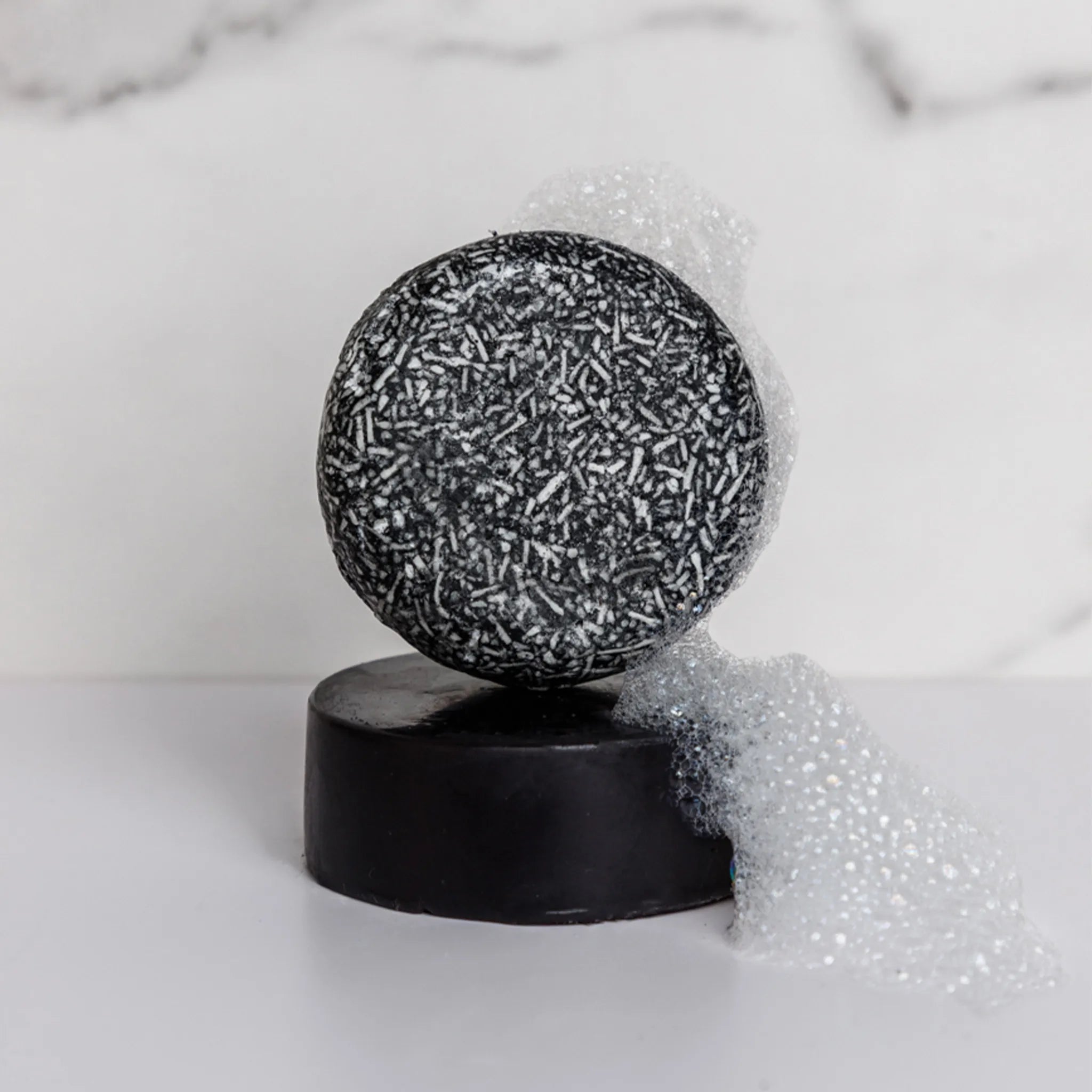 charcoal shampoo bar stacked on bar conditoner that is charcoal too