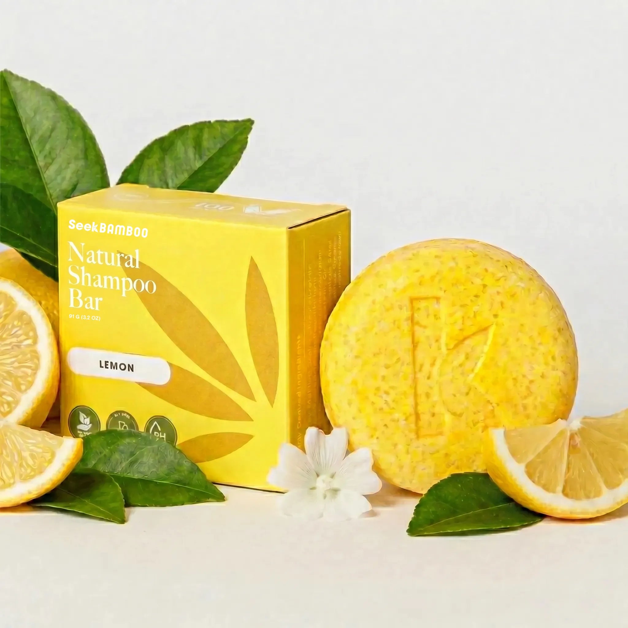 lemon natural shampoo bar with packaging, lemon slices, and leaves on a light background