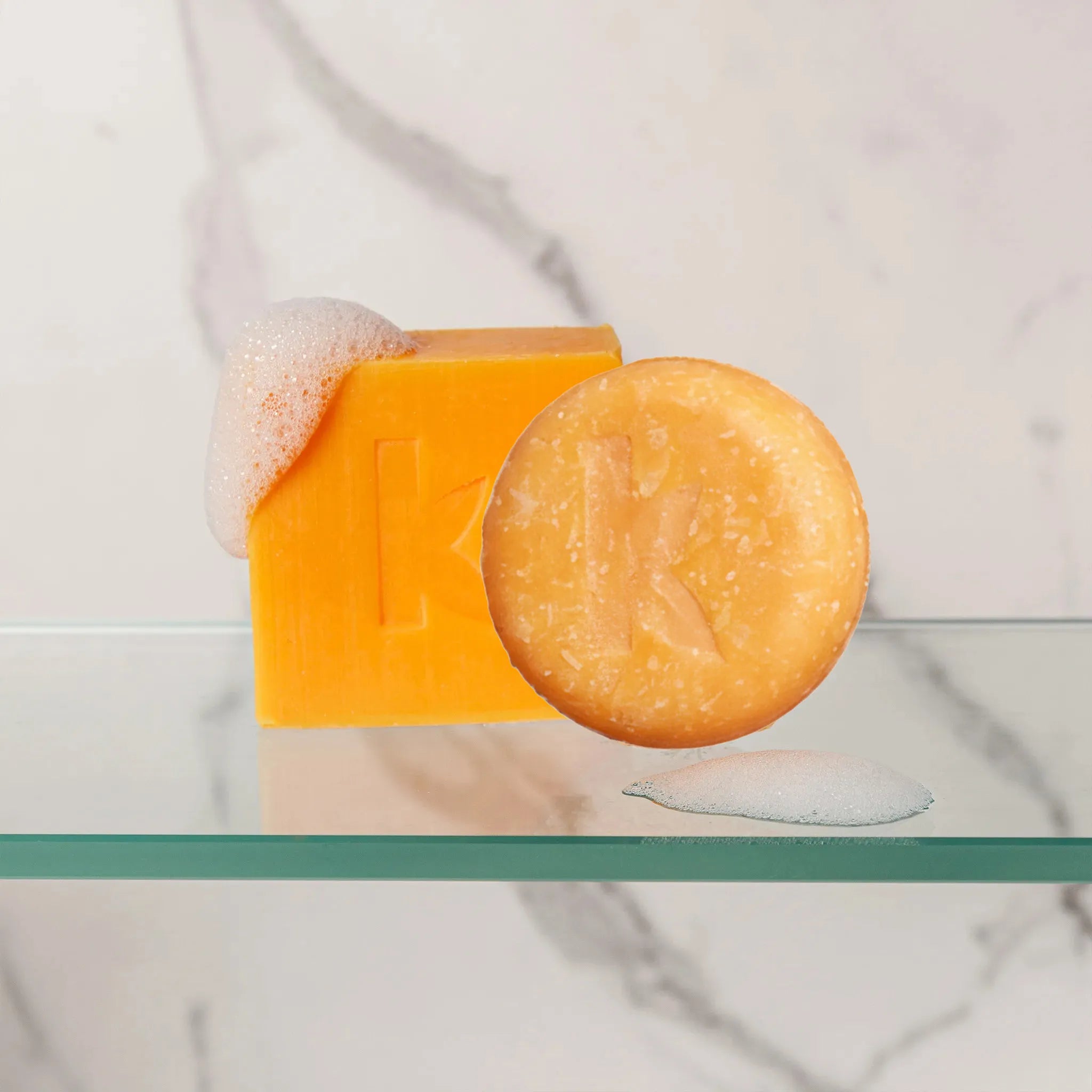 honey shampoo and soap bars sitting on glass