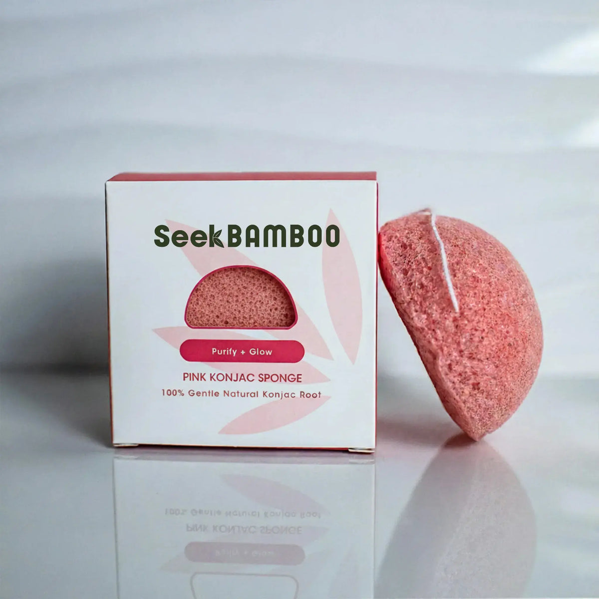 A pink clay konjac sponge beside its Seek Bamboo packaging