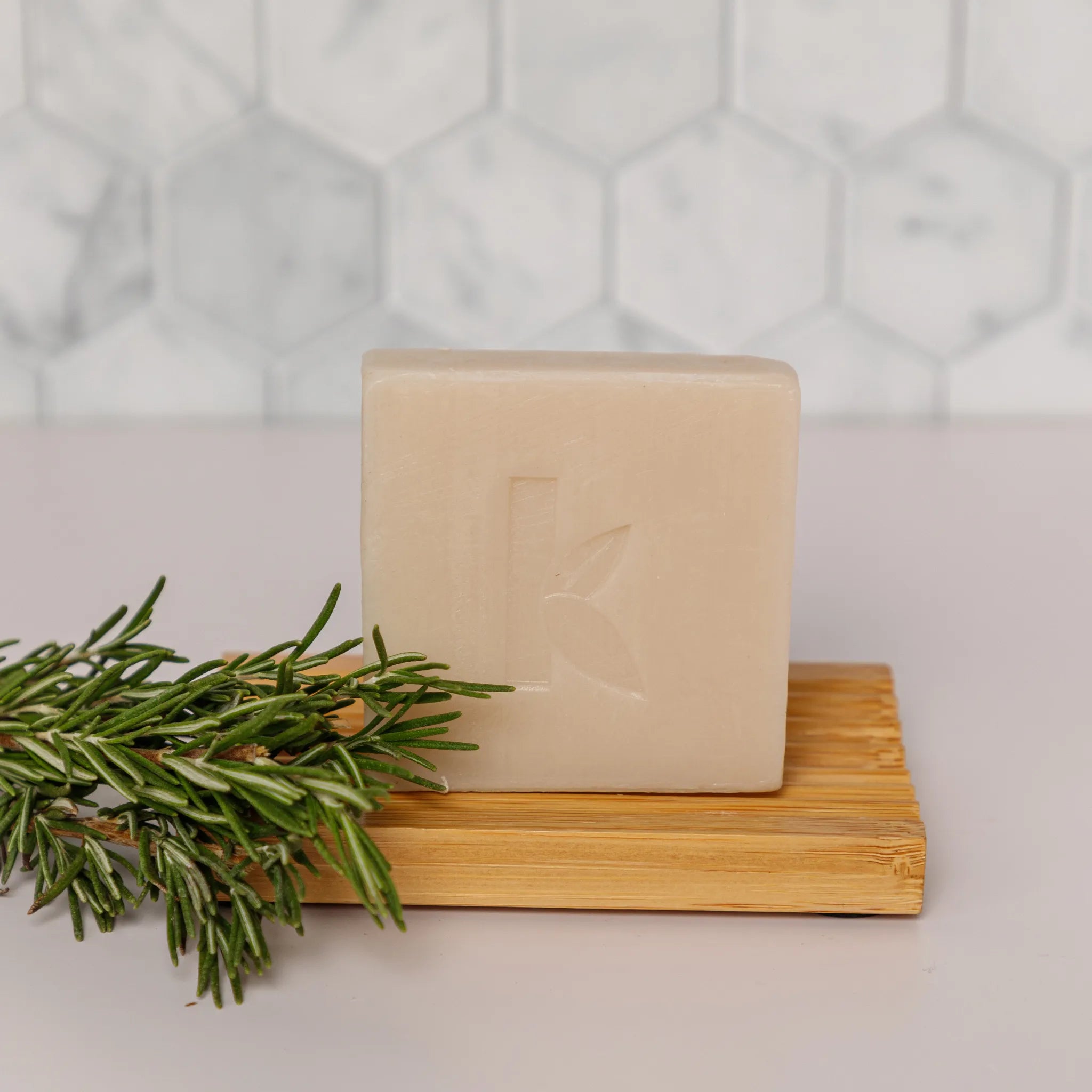 rosemary body soap bar stacked on a bamboo dish