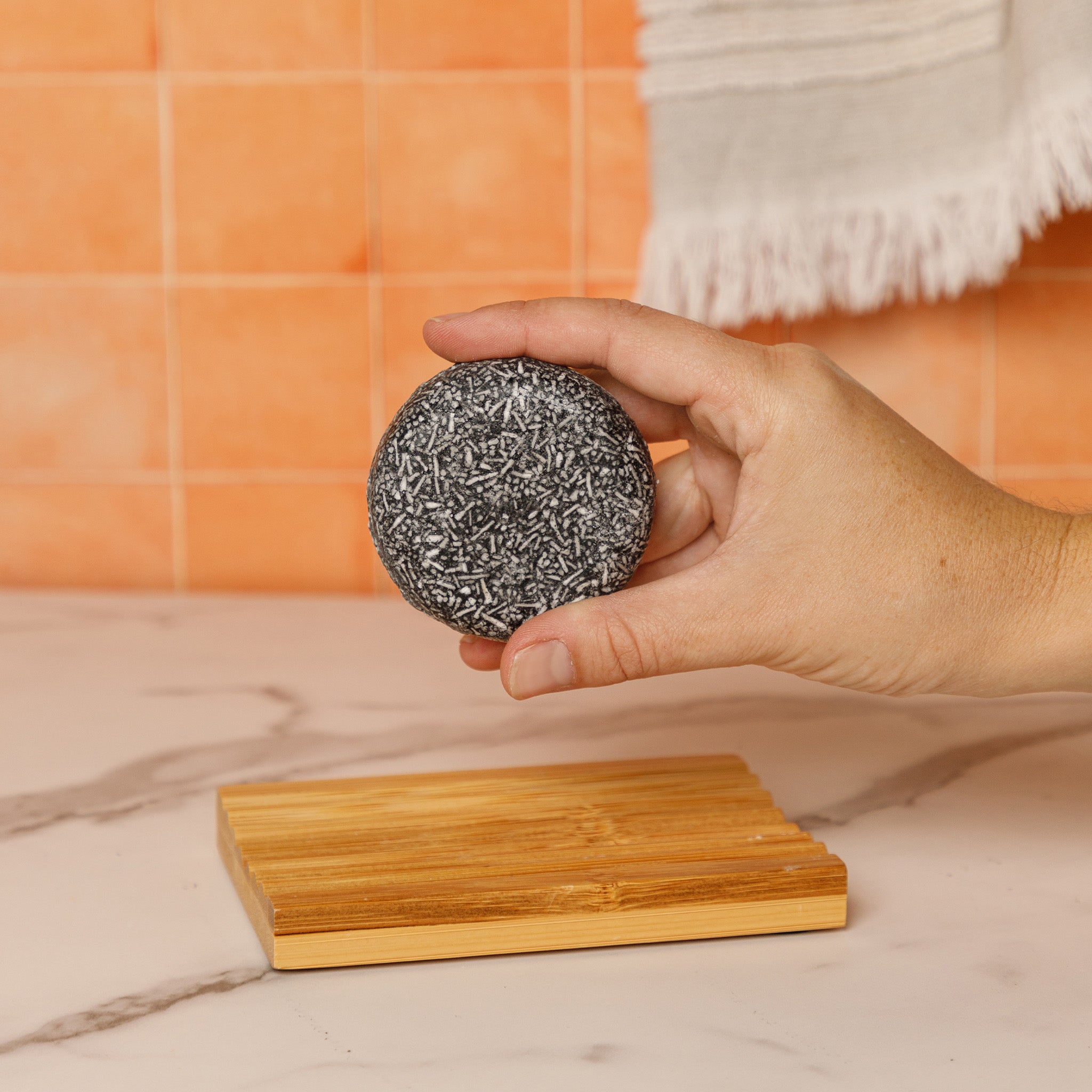 charcoal shampoo held in the air