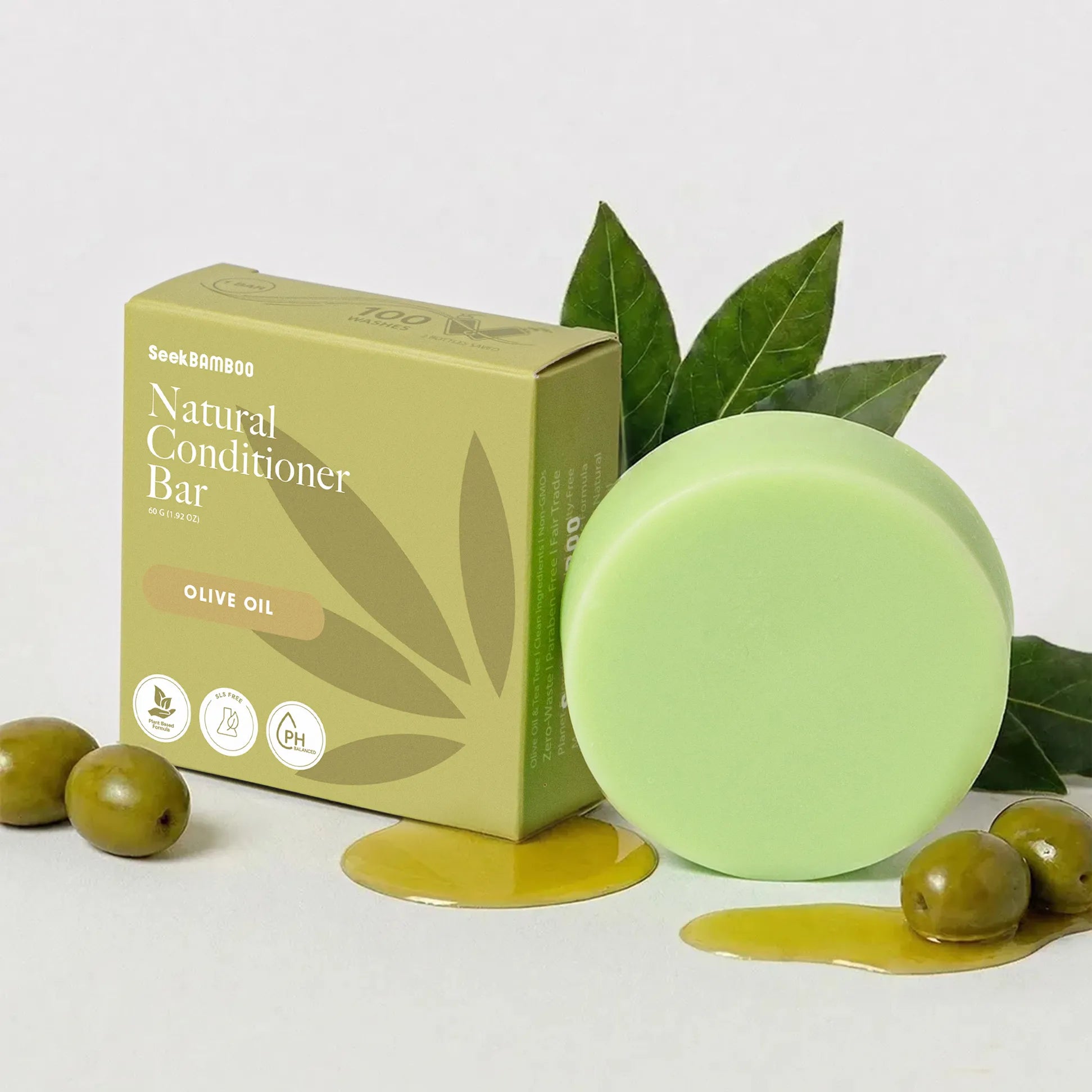 curly hair conditioner bar with packaging and olives on a light gray background