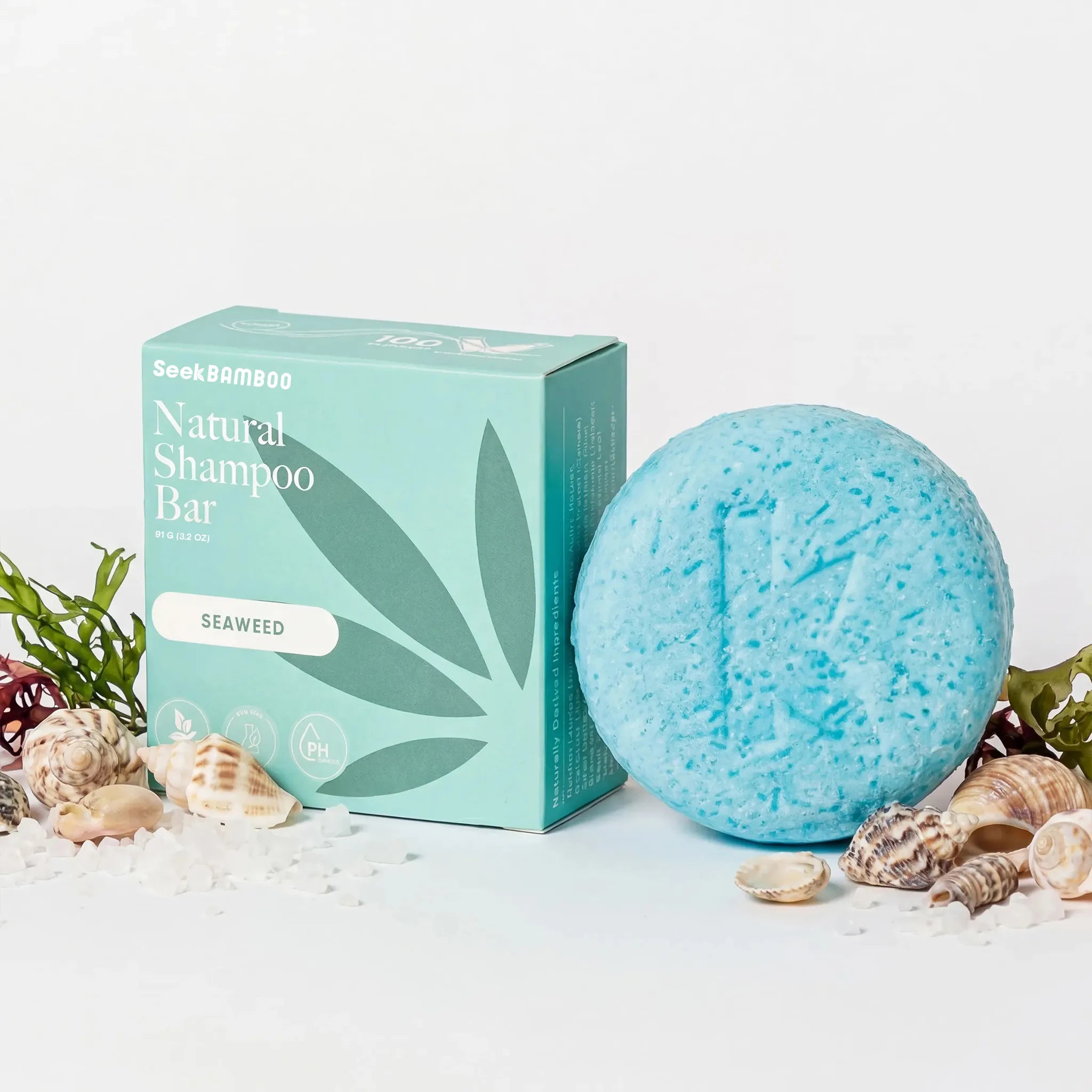 seaweed curly shampoo bar with packaging on a white background with seashells as a main product image