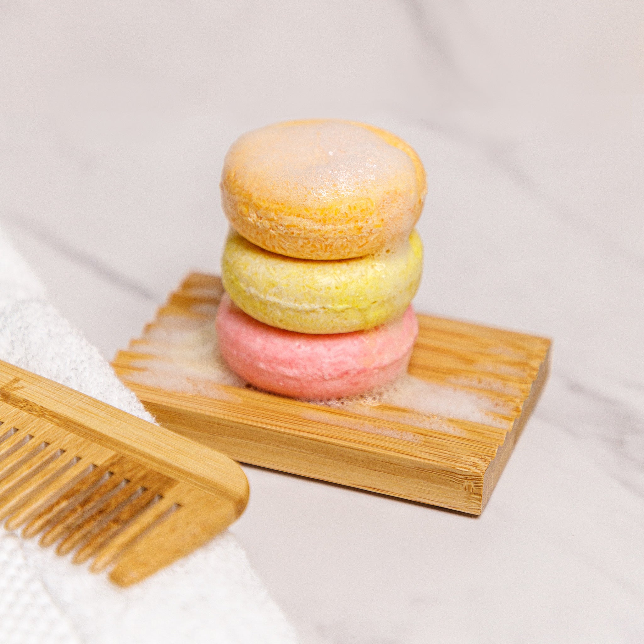 bamboo soap dish with shampoo bar stack and a bamboo comb