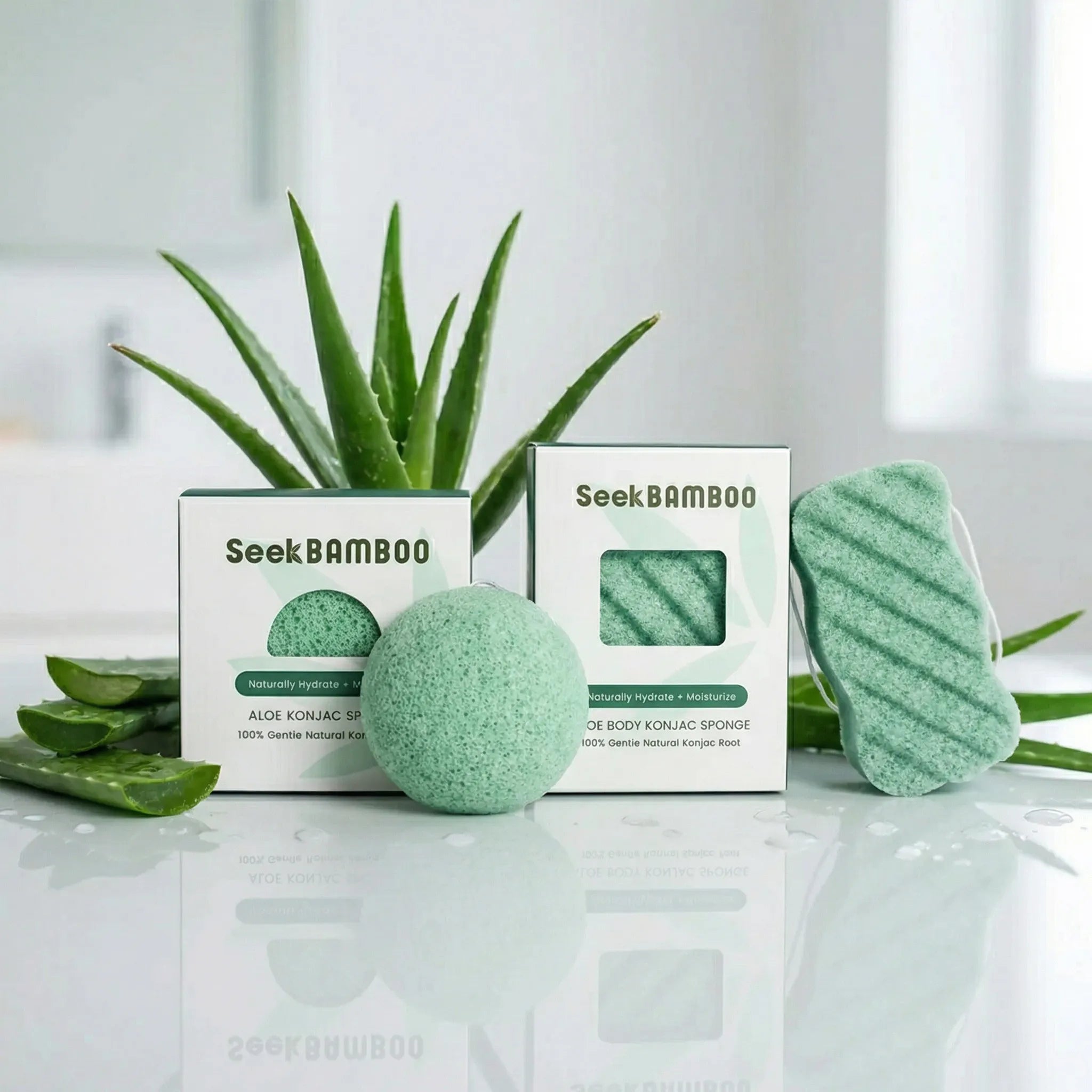 Seek Bamboo aloe konjac sponges 
on a reflective surface with a plant in the background.