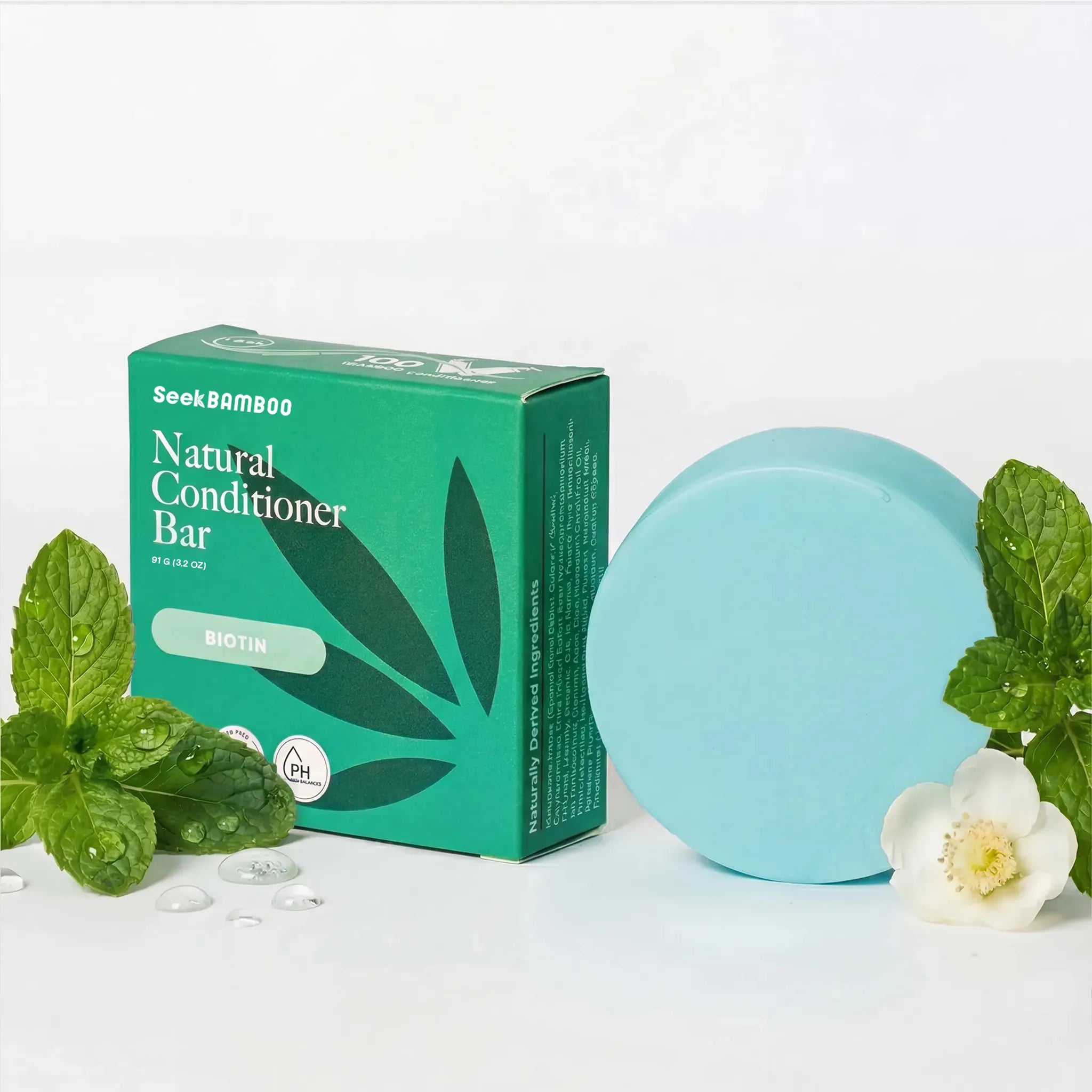 Natural conditioner bar with packaging and mint leaves on a white background