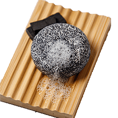 bamboo dish rack holding a charcoal shampoo bar by seek bamboo