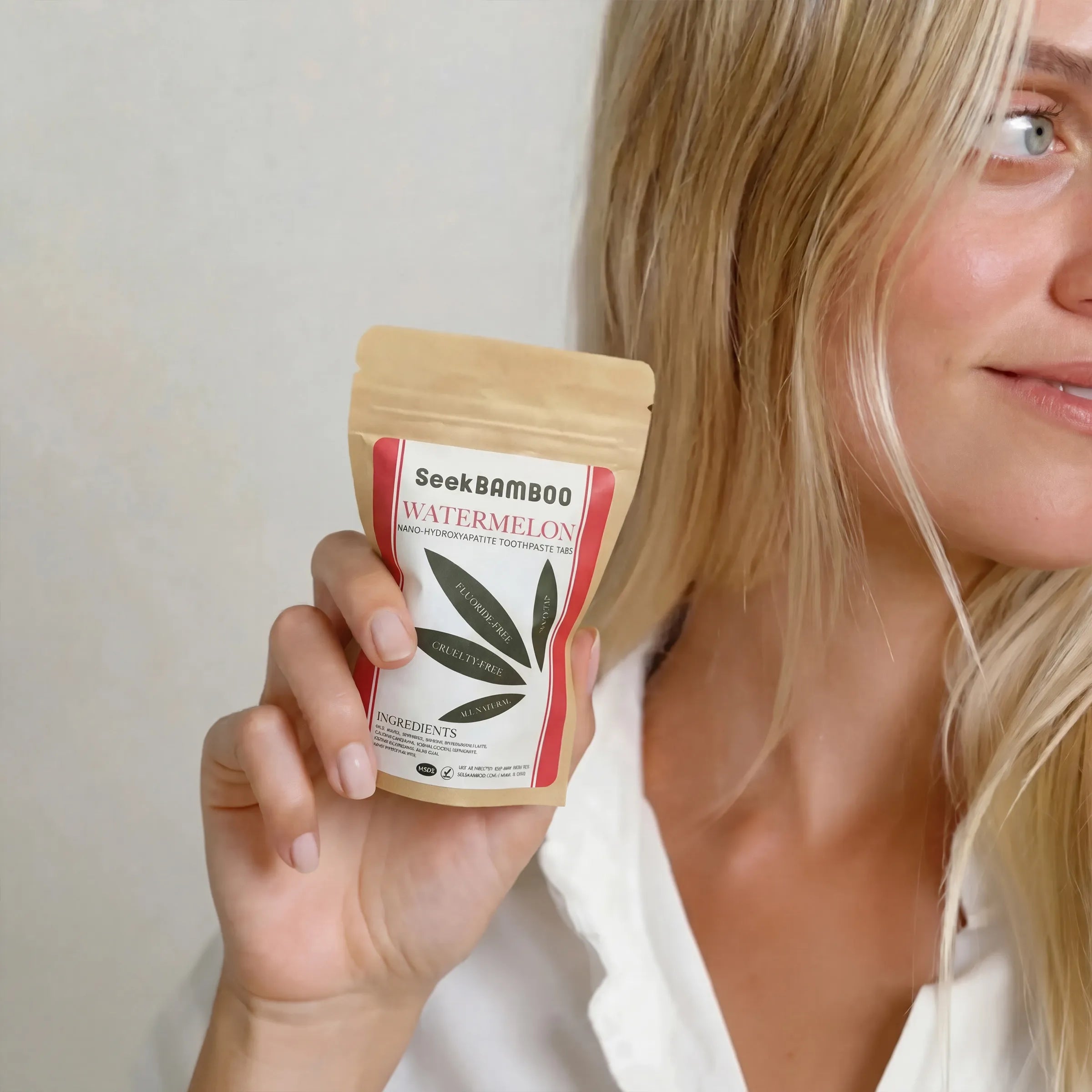 Woman holding a SeekBamboo watermelon product package against a plain background