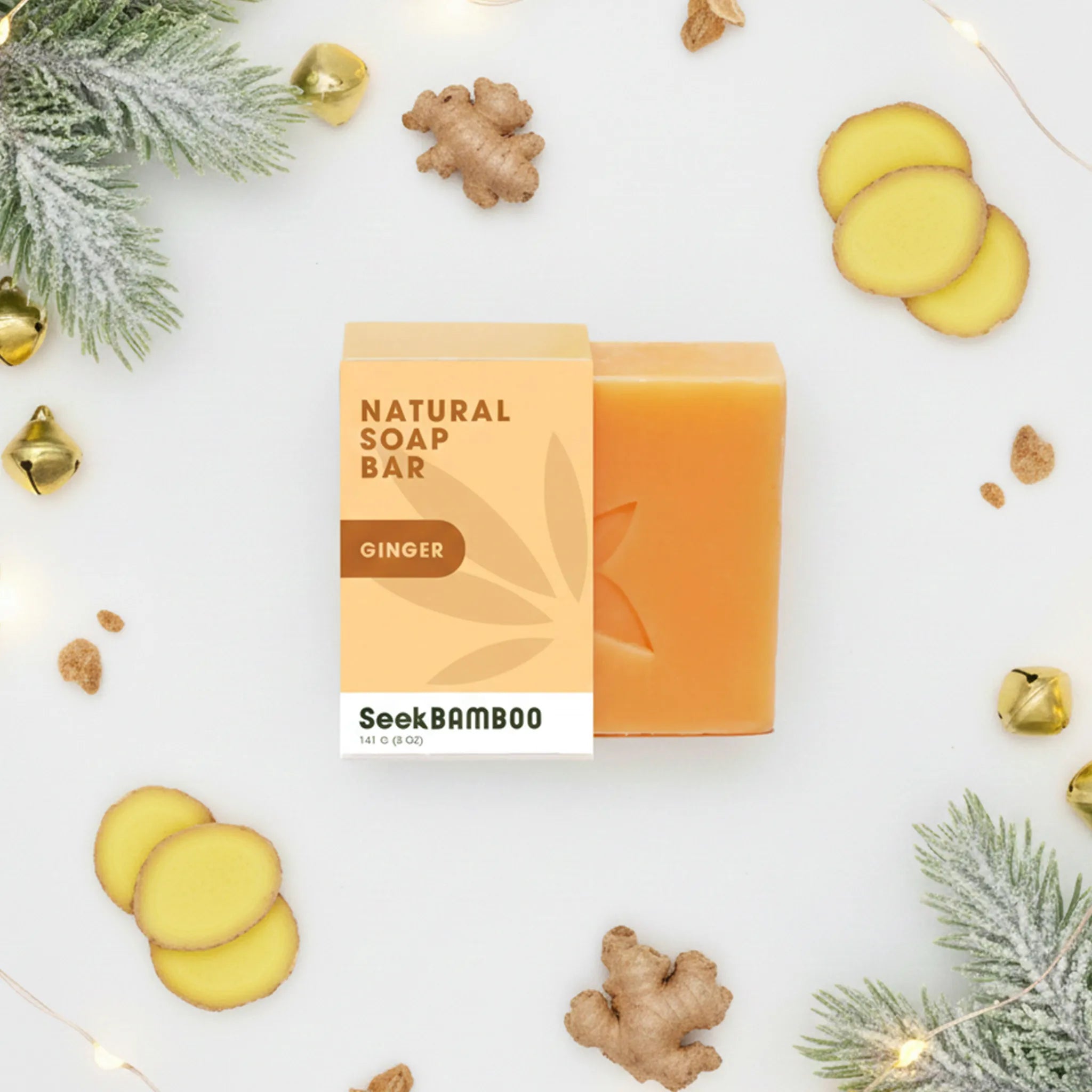 SeekBAMBOO ginger soap bar with packaging on a decorative background with ginger slices and leaves.