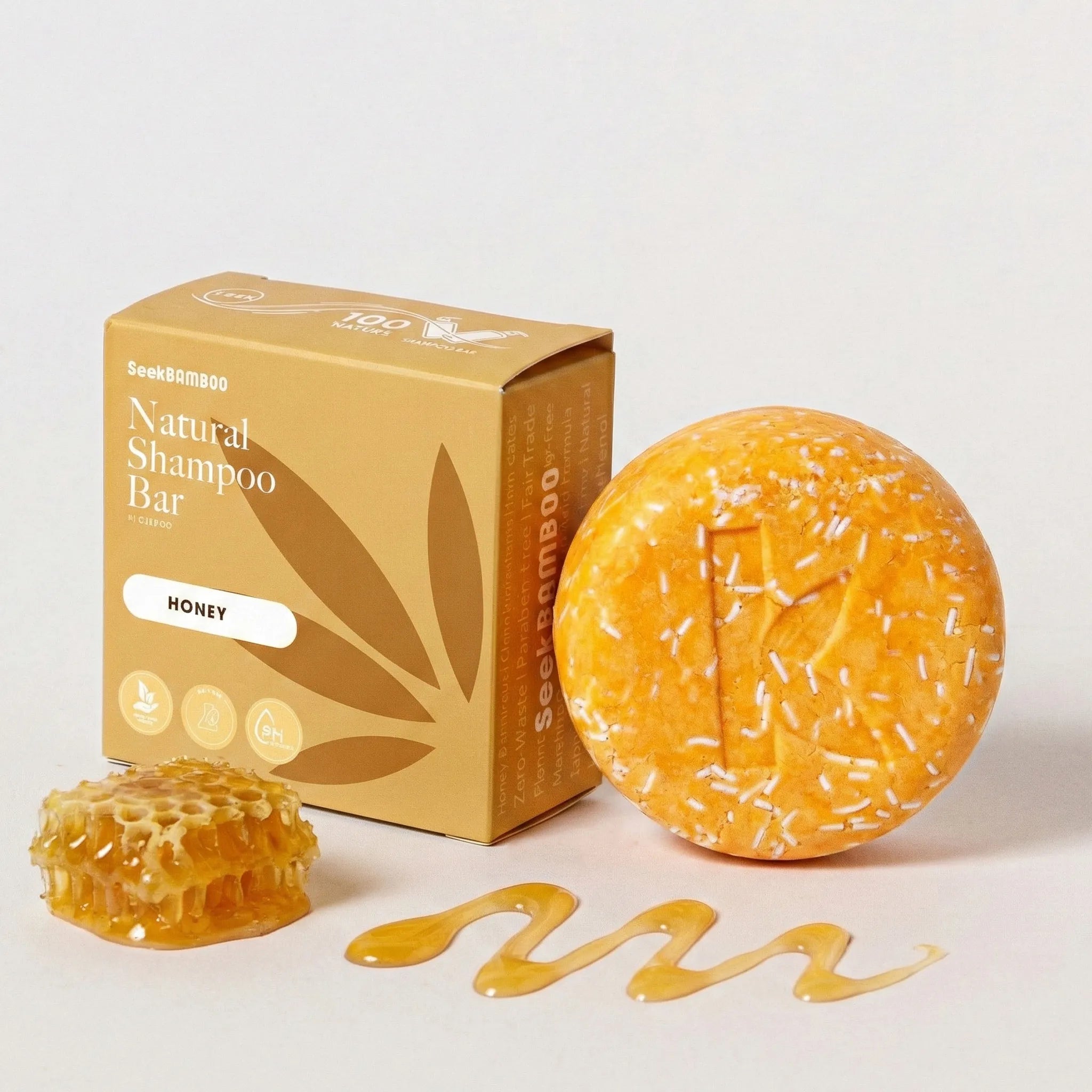 Honey-scented shampoo bar with packaging on a white background