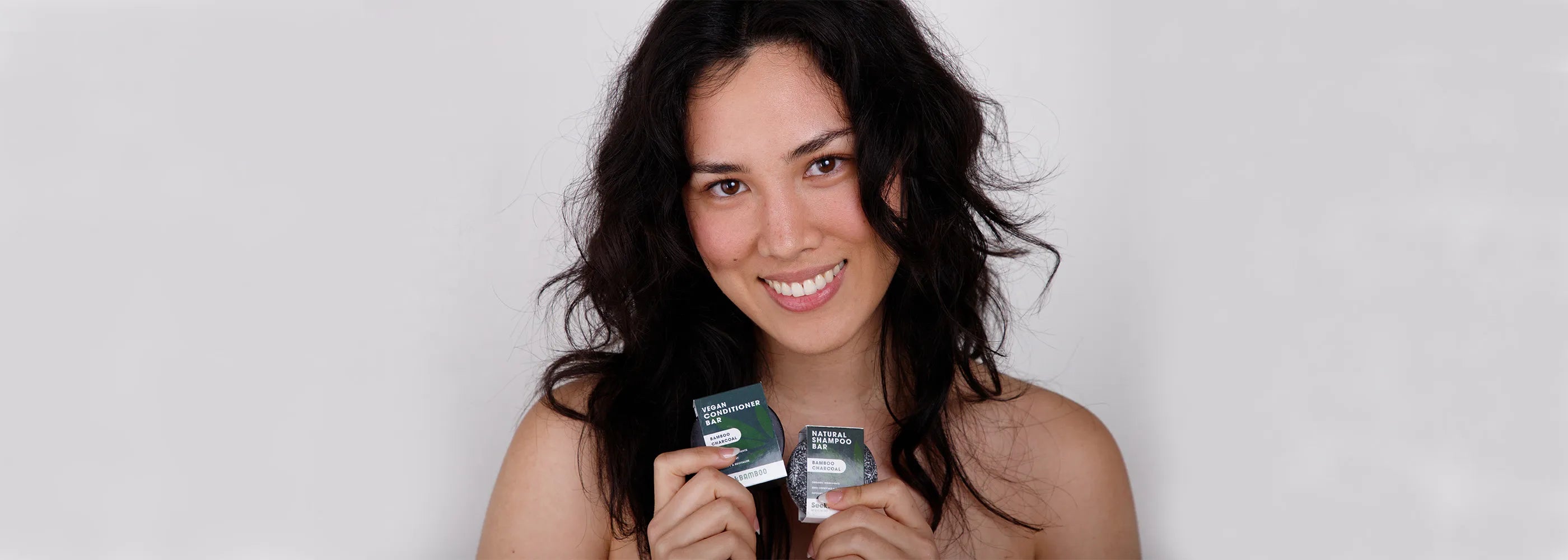 a woman holding a charcoal shampoo bar