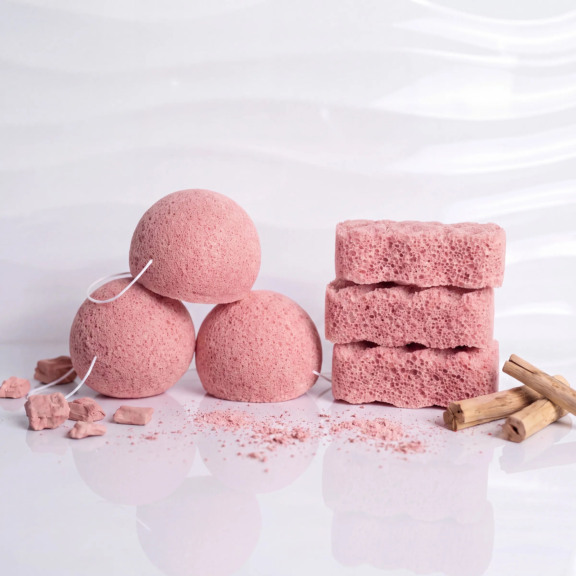 Pink face and body sponges display with pink clay rocks and powder.