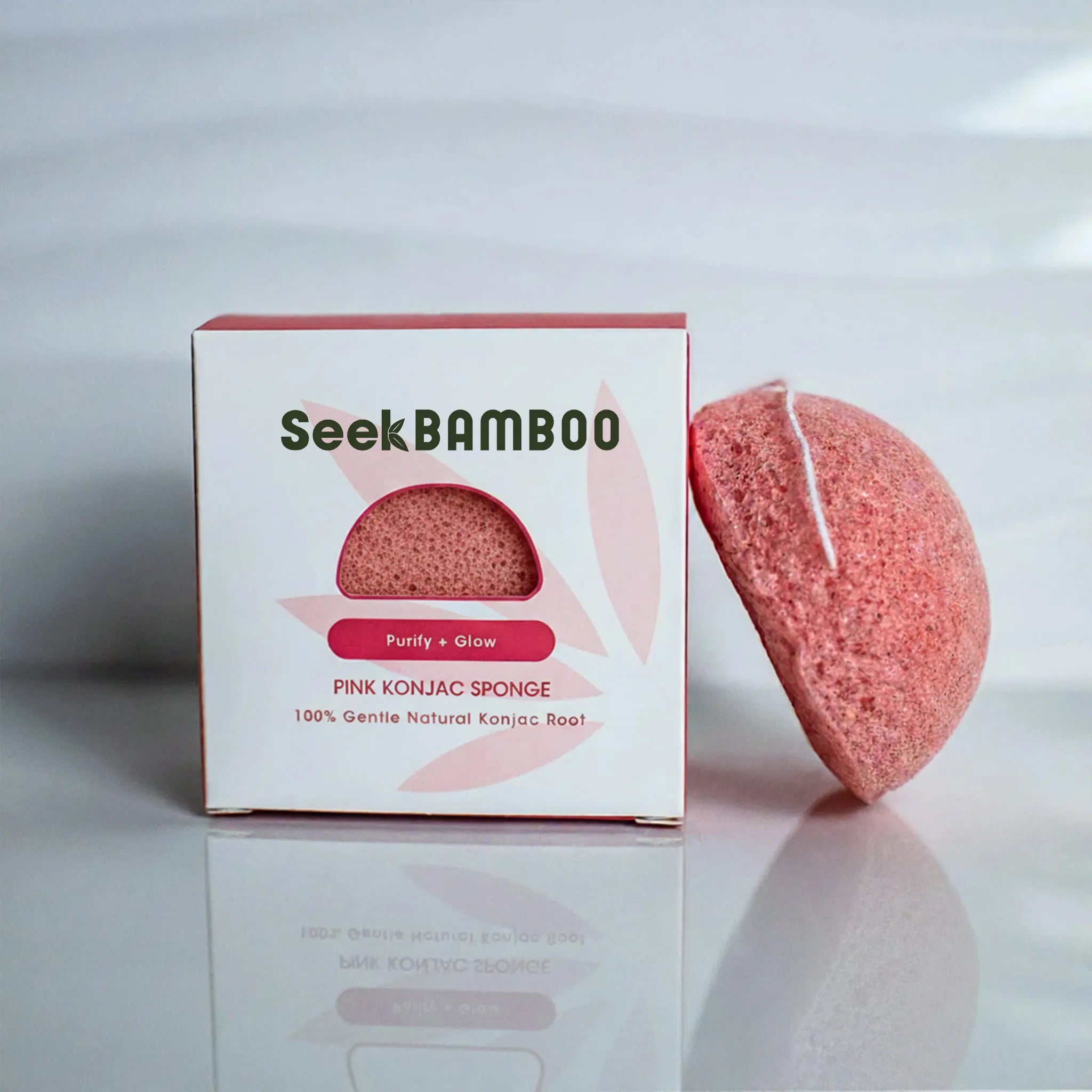 Pink konjac sponge with Seek Bamboo packaging on a reflective surface