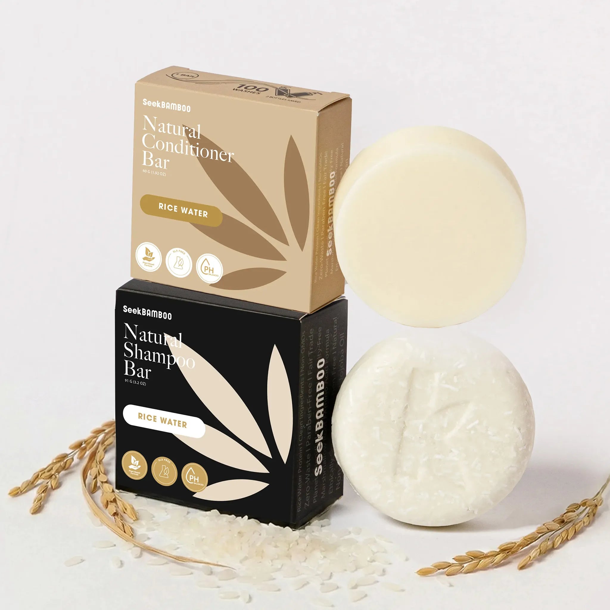 Two rice water shampoo bars and their packaging on a light background with rice grains.