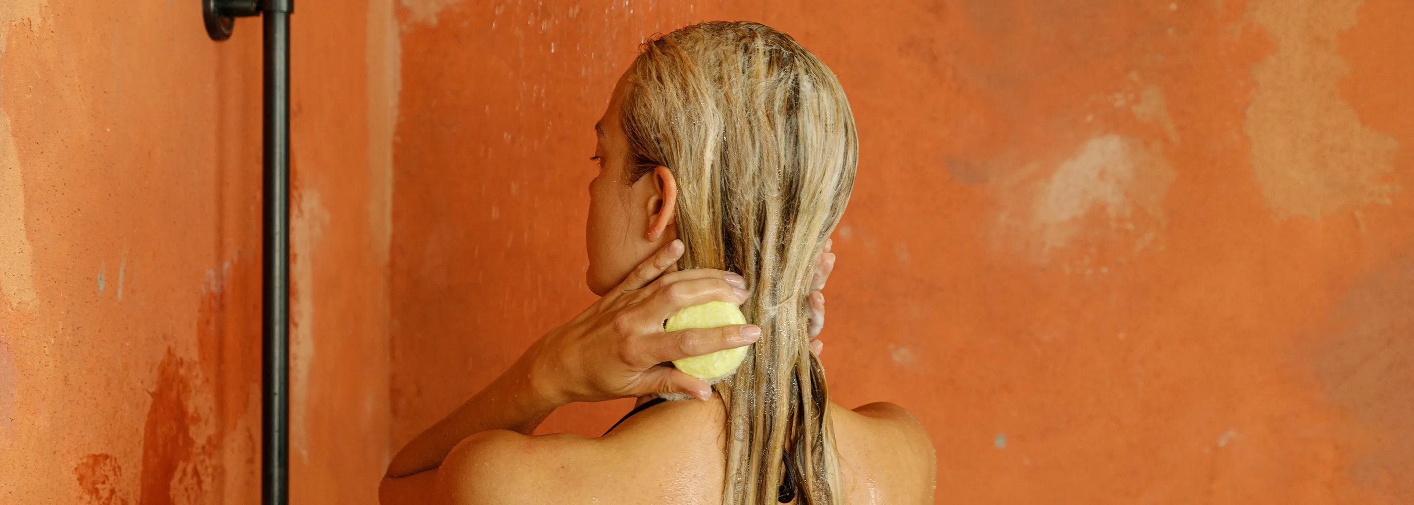 woman showing using sls free haircare shampoo and conditioner bar