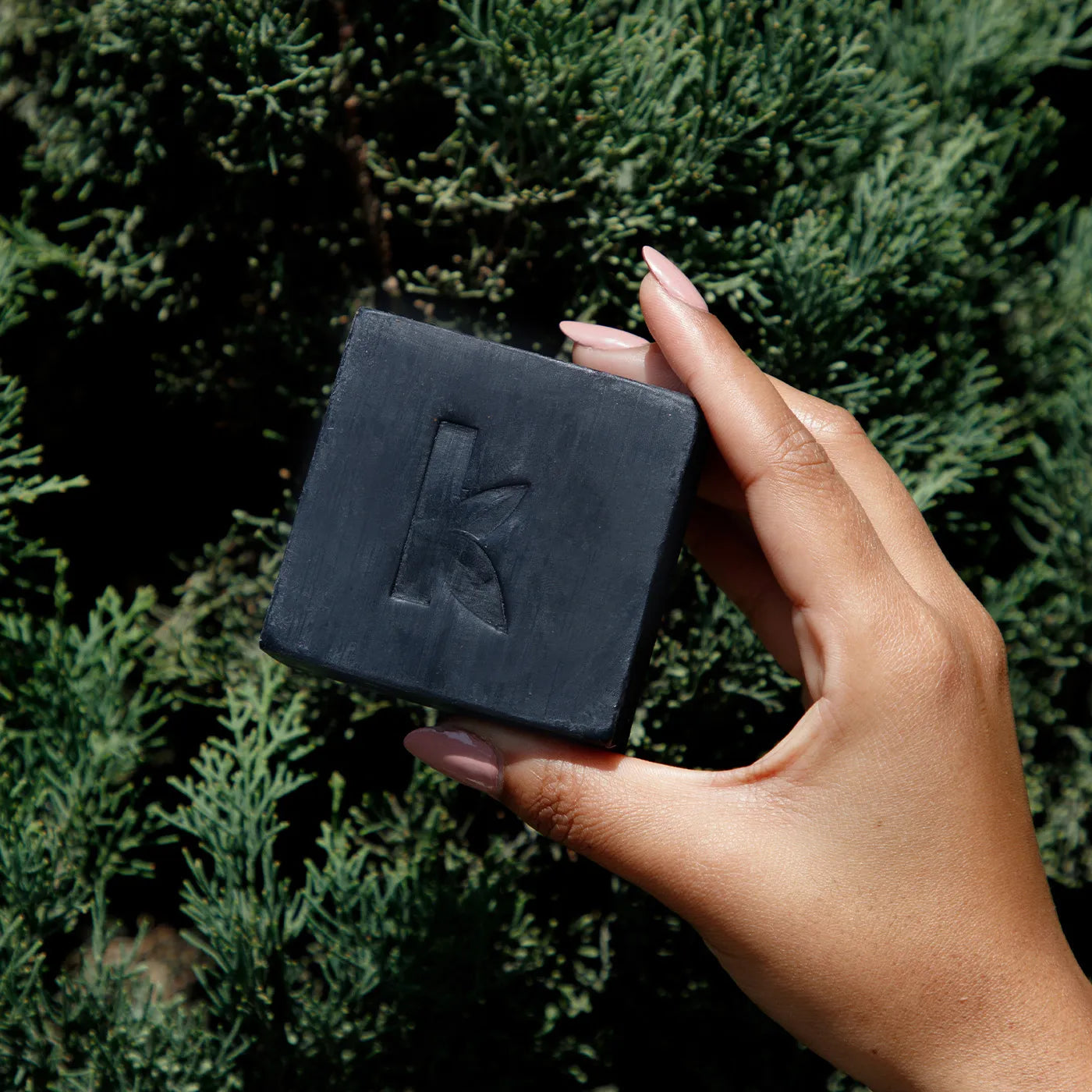 a female hand holding a charcoal soap bar from Seek Bamboo