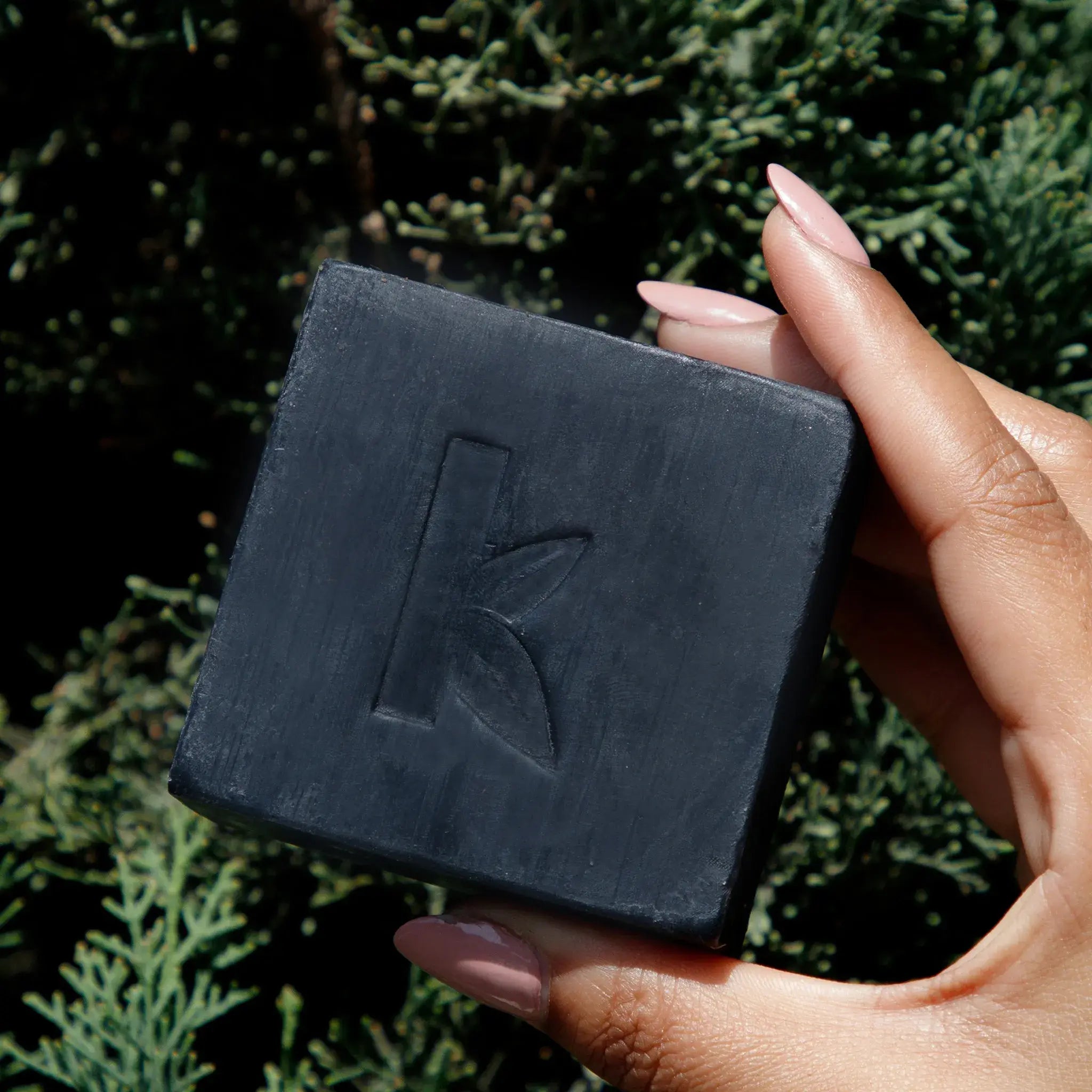 an activated charcoal soap​ held in a hand