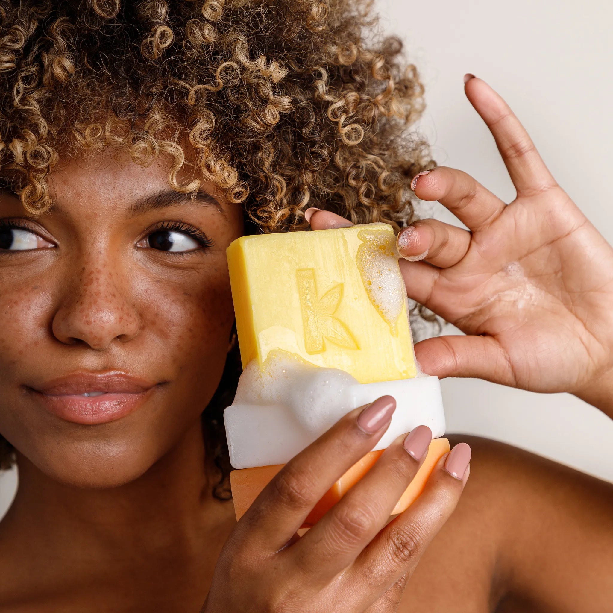 woman holding a bar soap stack kojic acid and turmeric