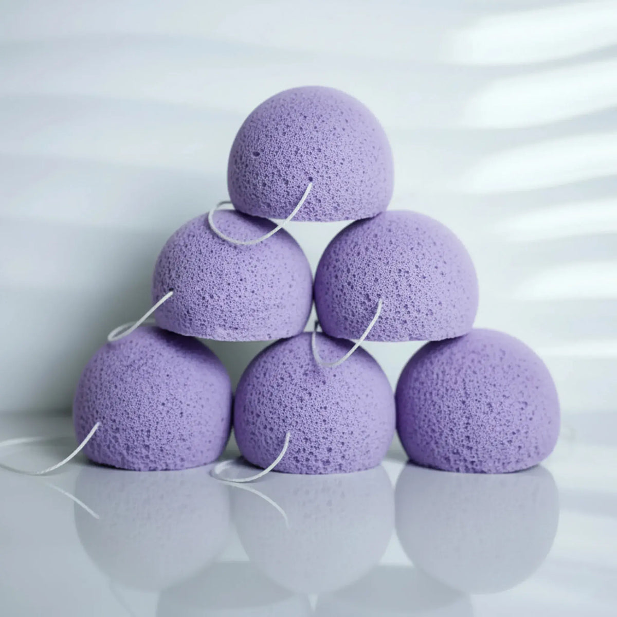 lavender konjac sponges stacked with 6 sponges in a pyramid