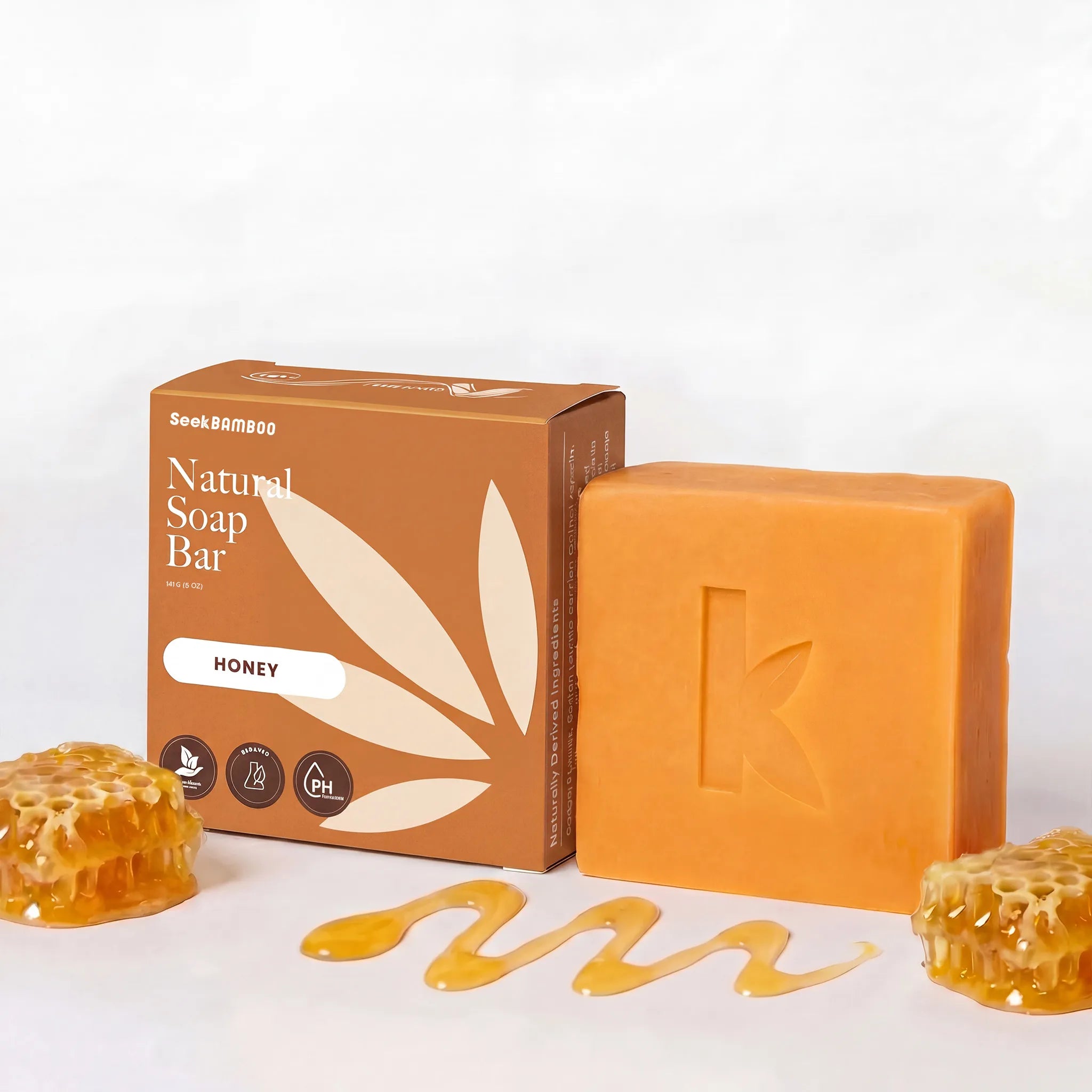 Orange moisturizing bar honey soap with packaging and honeycomb elements on a white background