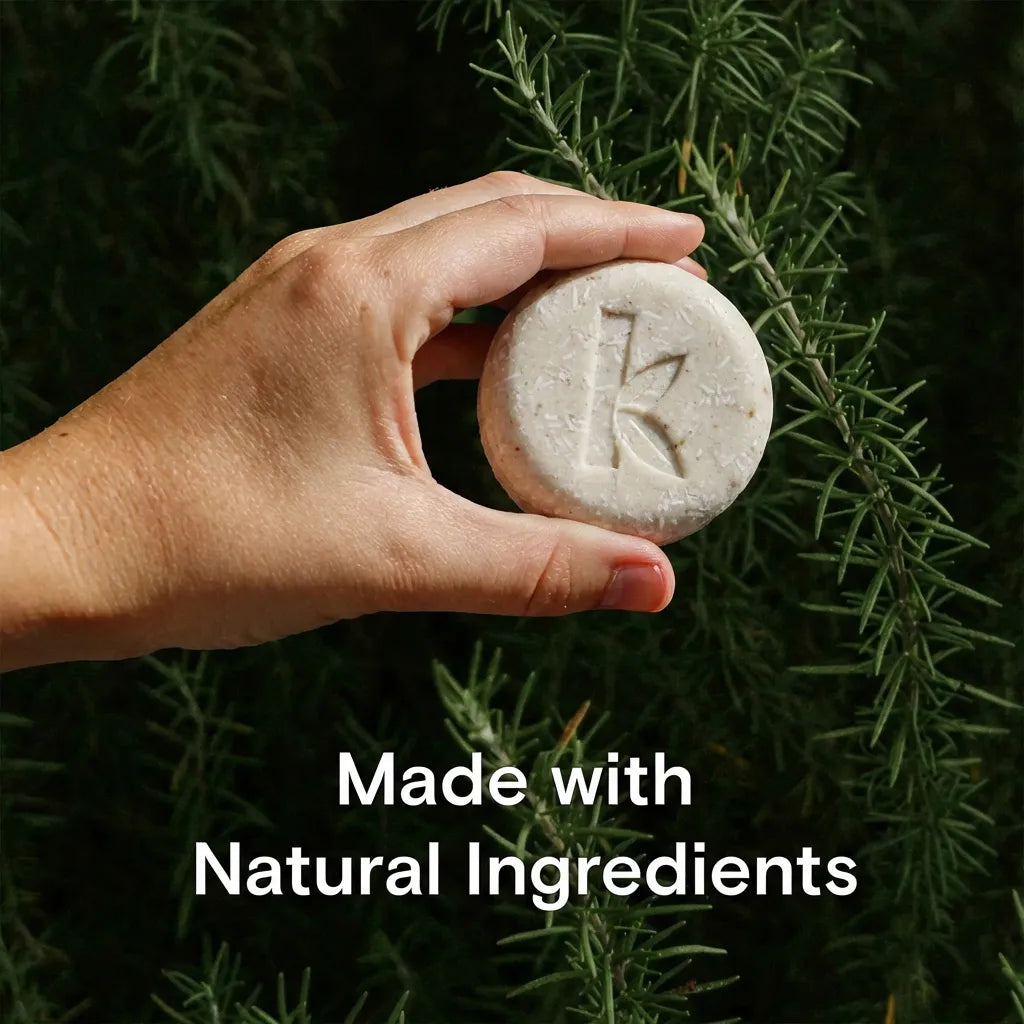 rosemary shampoo held up on a rosemary backgorund