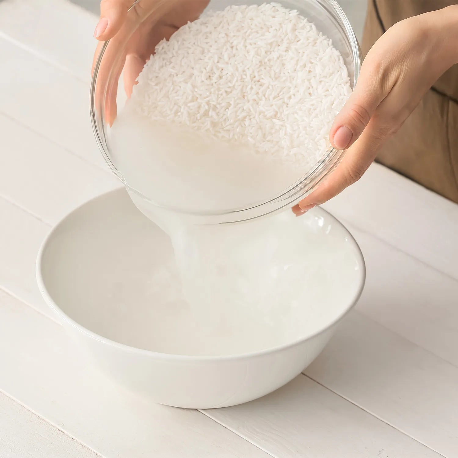 a photo of rice water being poured in to a bowl depicting the rice extract in the seek bamboo rice water shampoo bar