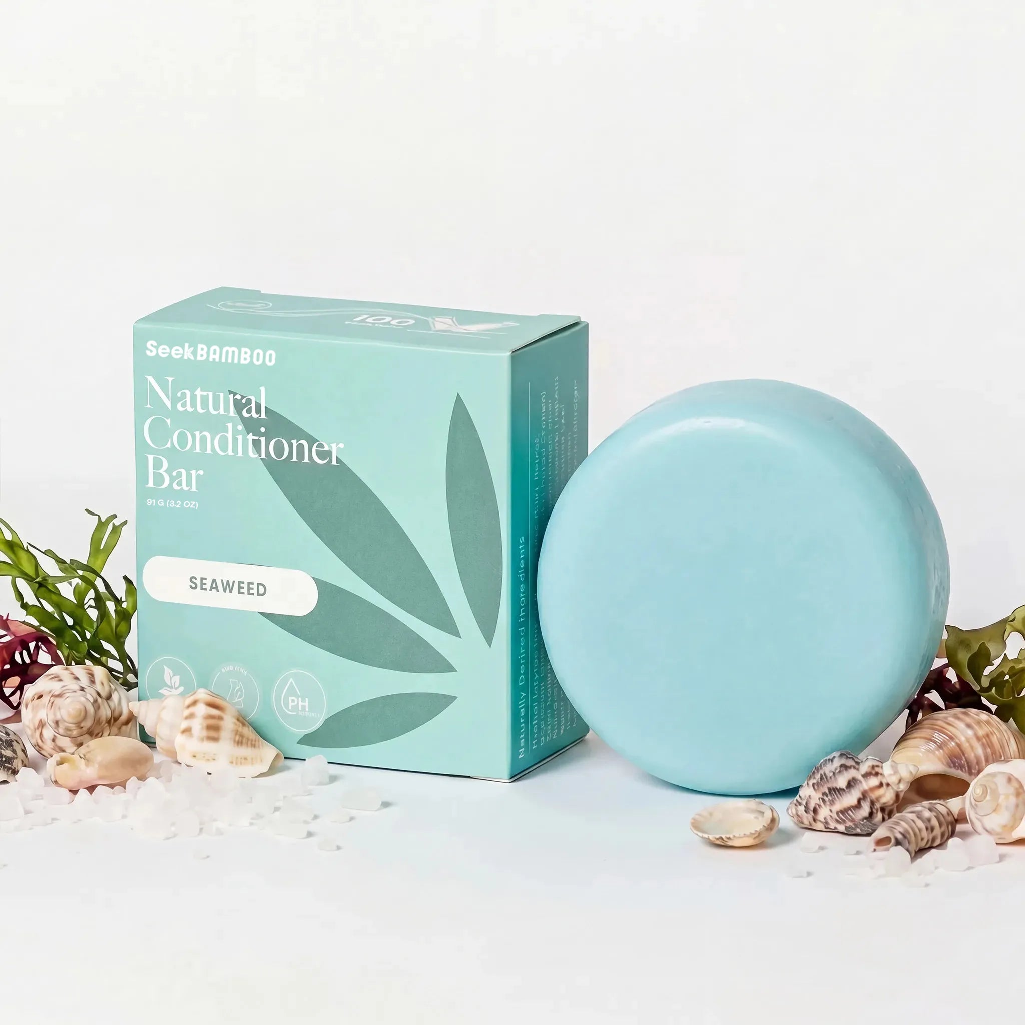 curly hair conditioner bar with packaging on a white background with seashells and seaweed as a main product image