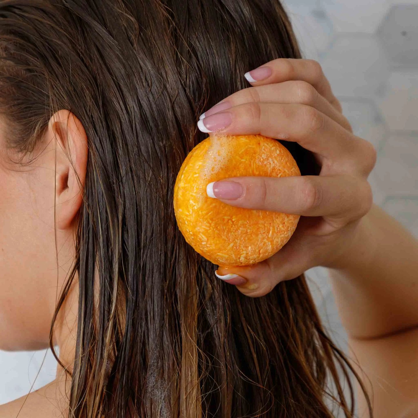 solid honey shampoo on the back of a womans head
