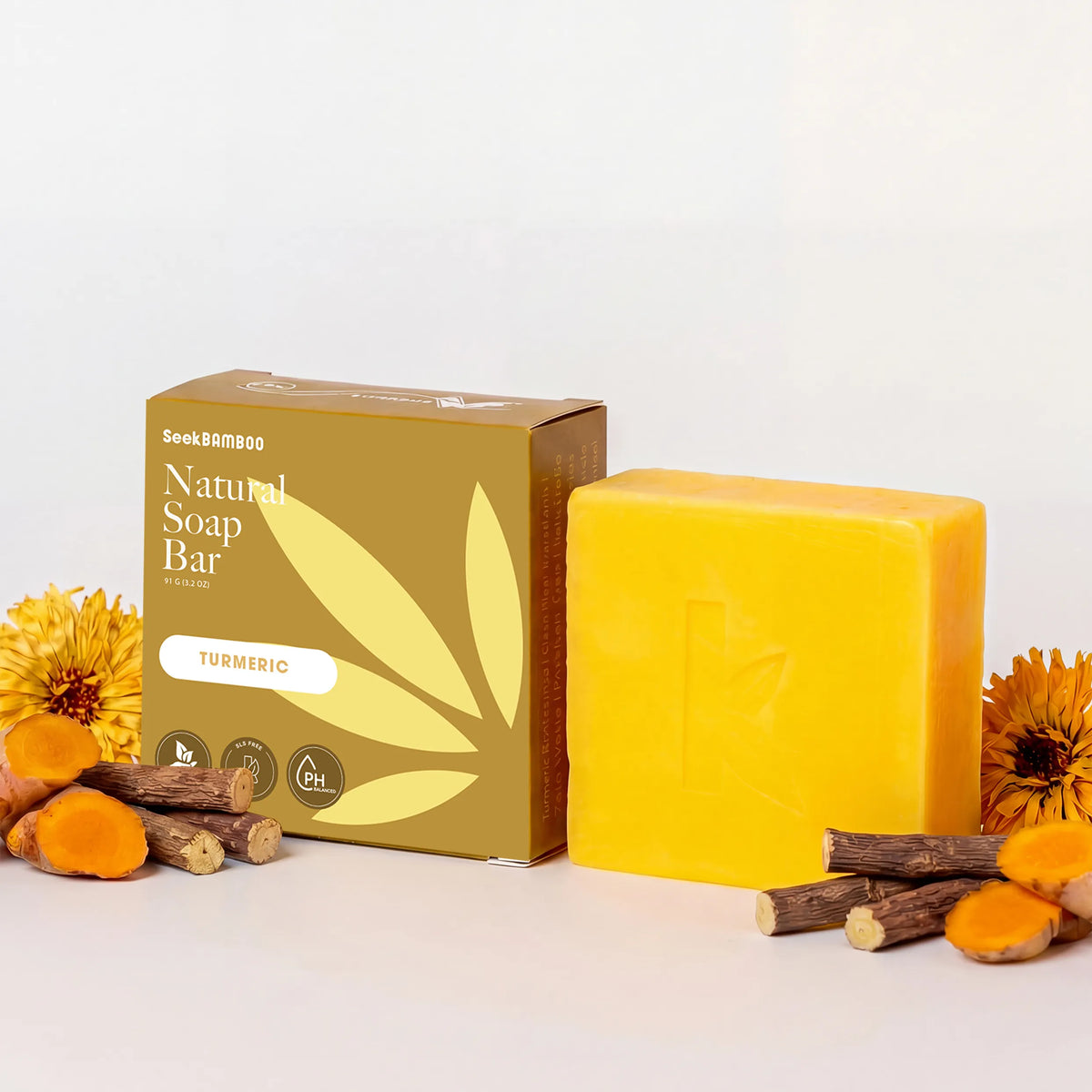 A bar of natural turmeric soap bar. The soap bar is a vibrant yellow, and the box is a warm brown on a white background.