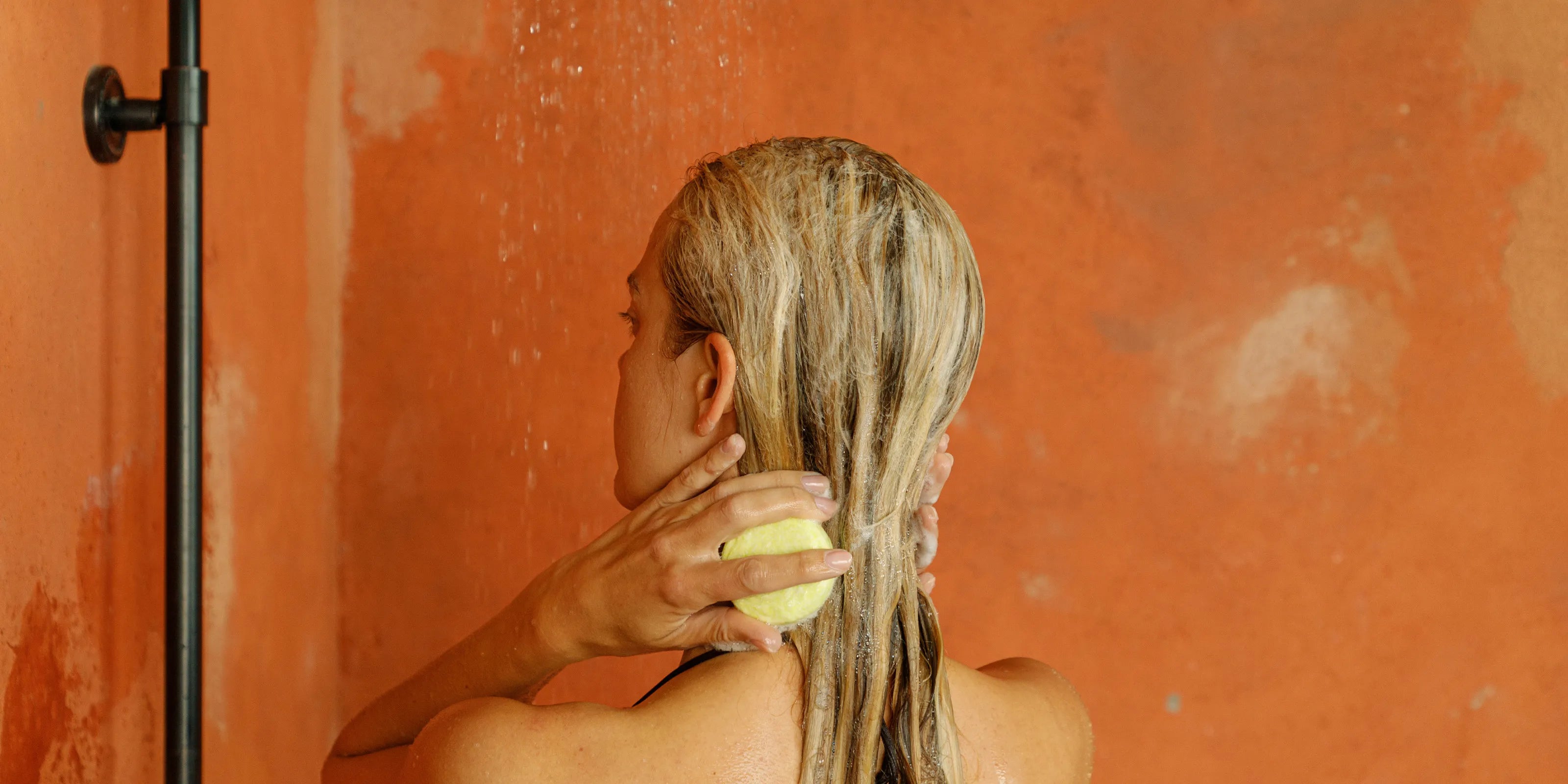 woman showering with a paraben-free shampoo bar